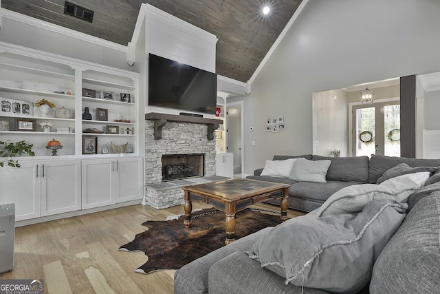 living room with a stone fireplace, light hardwood / wood-style floors, wooden ceiling, high vaulted ceiling, and ornamental molding