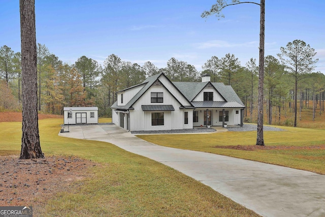 modern inspired farmhouse with covered porch, a front lawn, and a storage shed