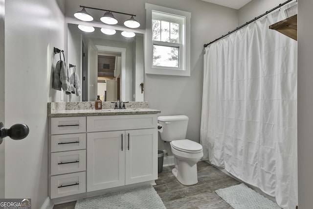 bathroom featuring toilet, vanity, and a shower with shower curtain