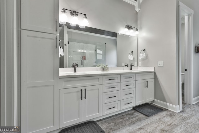 bathroom with an enclosed shower, vanity, and hardwood / wood-style floors