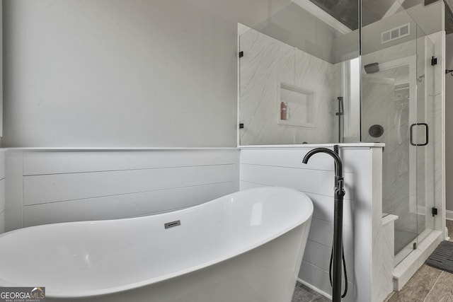 bathroom featuring separate shower and tub and hardwood / wood-style flooring