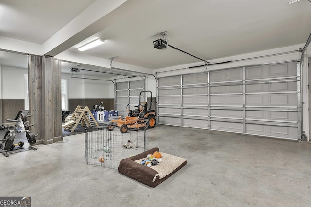 garage with a garage door opener and wooden walls