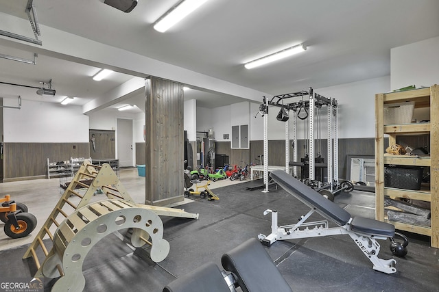 workout area featuring electric panel and wooden walls