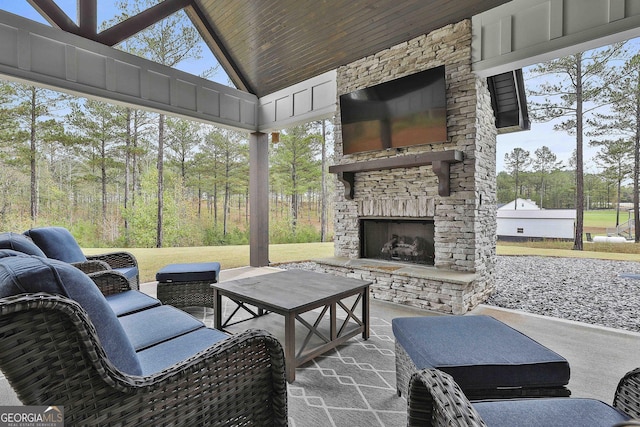 sunroom with an outdoor stone fireplace, wooden ceiling, and vaulted ceiling