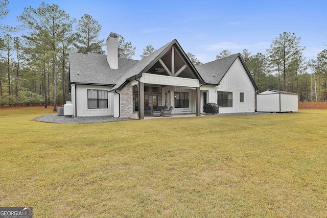 back of house featuring a shed, a patio, and a lawn