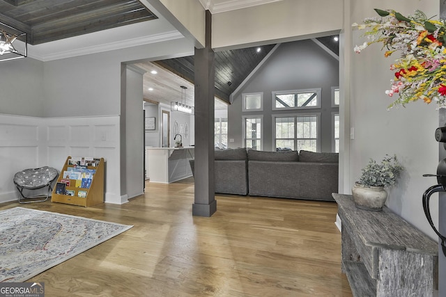 living room with high vaulted ceiling, hardwood / wood-style floors, and crown molding