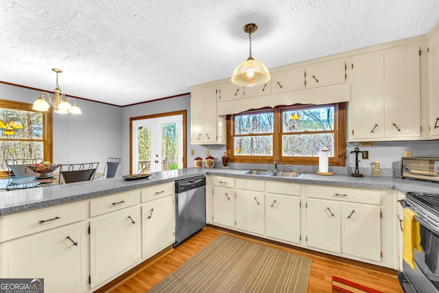 kitchen with hanging light fixtures, stainless steel appliances, cream cabinets, and sink