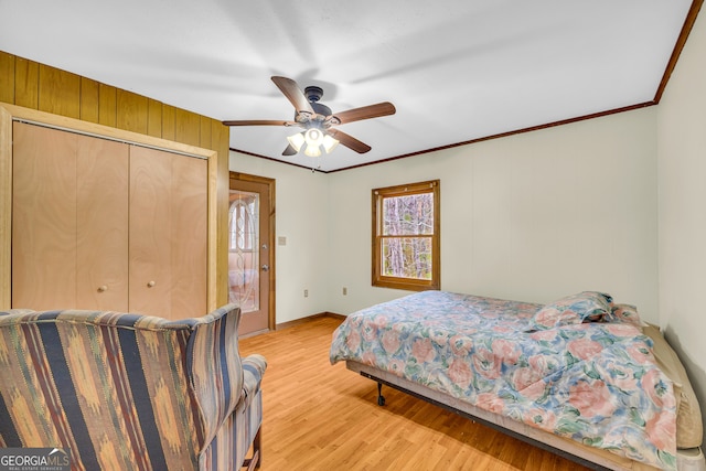 bedroom featuring light hardwood / wood-style floors, a closet, crown molding, and ceiling fan