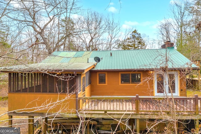 exterior space with a sunroom and a wooden deck