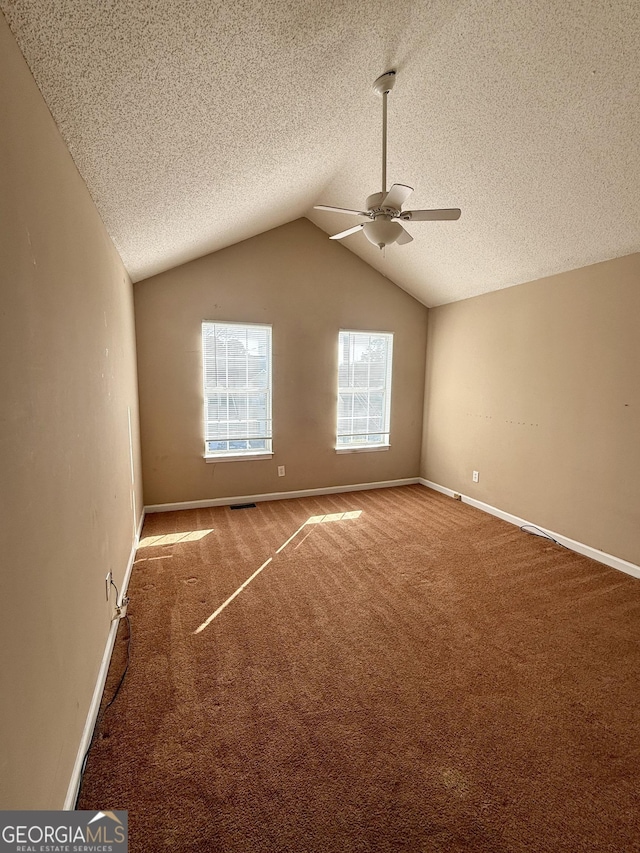 carpeted spare room with lofted ceiling, ceiling fan, and a textured ceiling