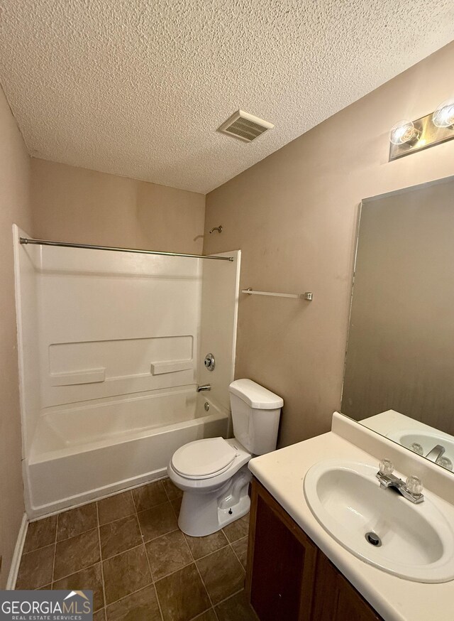 full bathroom featuring shower / bathing tub combination, toilet, a textured ceiling, tile patterned floors, and vanity