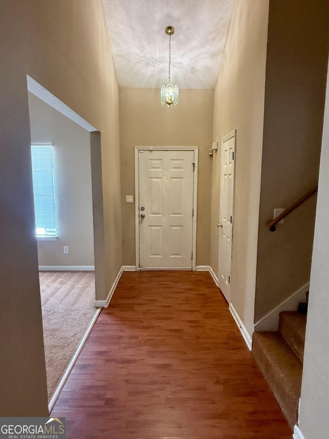 interior space with a high ceiling, a notable chandelier, and wood-type flooring