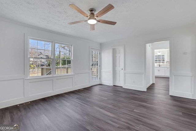 interior space with dark hardwood / wood-style flooring, ceiling fan, and a textured ceiling