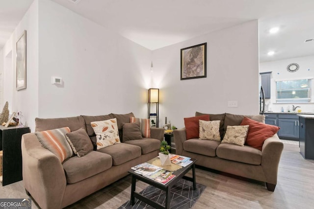 living room featuring light wood-type flooring and sink