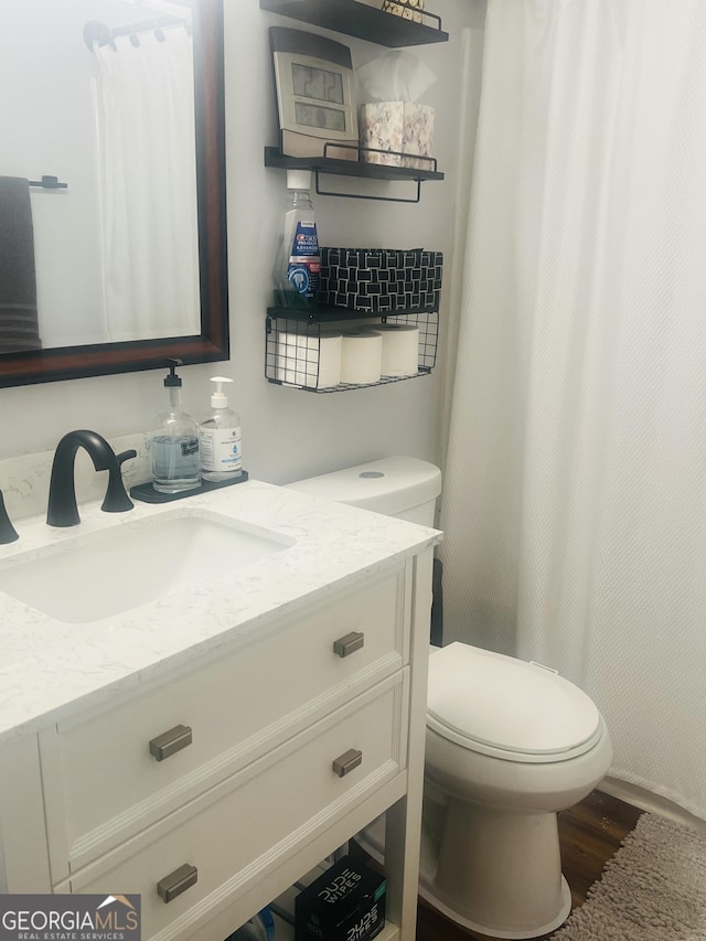 bathroom featuring hardwood / wood-style flooring, vanity, and toilet