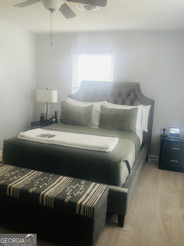 bedroom with ceiling fan and light carpet