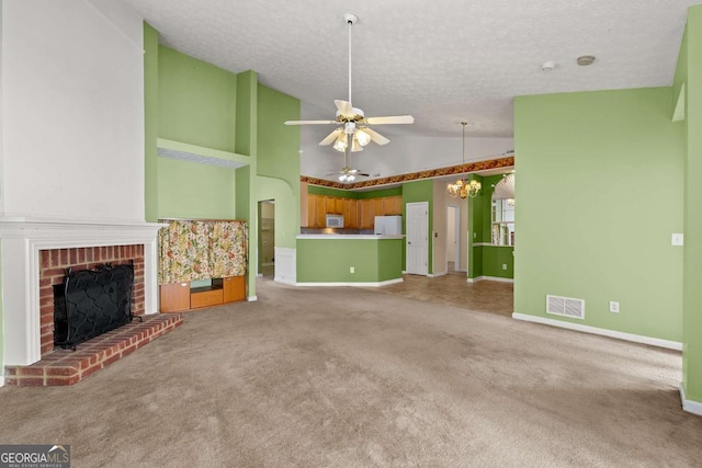 unfurnished living room featuring carpet, a brick fireplace, a textured ceiling, high vaulted ceiling, and ceiling fan with notable chandelier