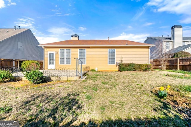 rear view of property featuring a yard