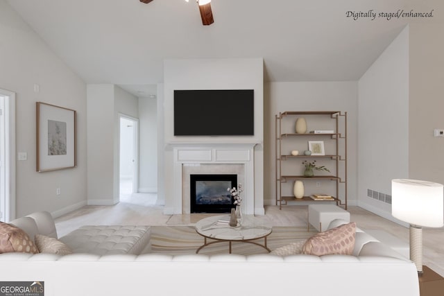 living area featuring visible vents, baseboards, a ceiling fan, and a high end fireplace