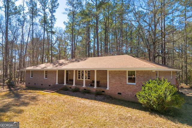 view of front of property featuring roof with shingles, brick siding, crawl space, and a front lawn