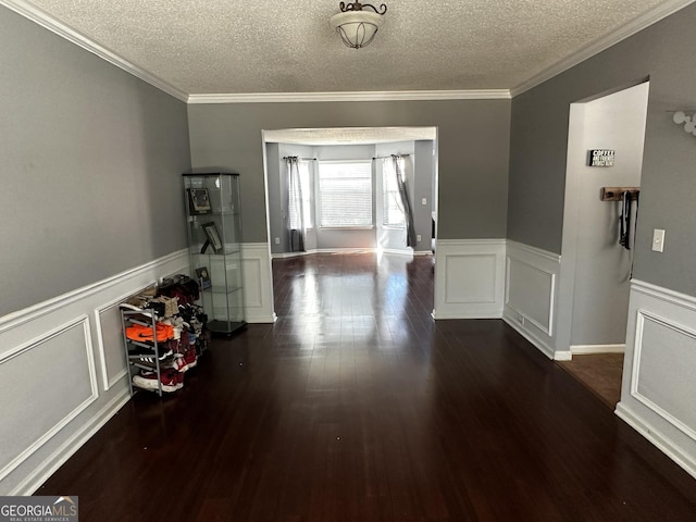 hallway featuring dark hardwood / wood-style flooring, ornamental molding, and a textured ceiling