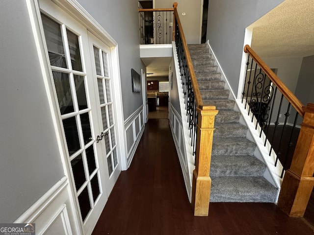 stairway featuring hardwood / wood-style flooring and french doors