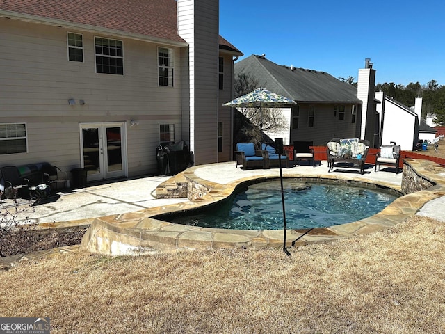 view of swimming pool with outdoor lounge area, french doors, and a patio area