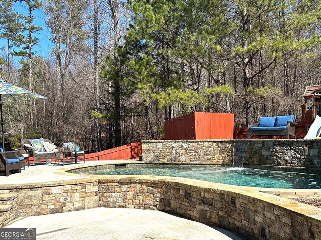view of swimming pool with pool water feature, a patio area, and outdoor lounge area