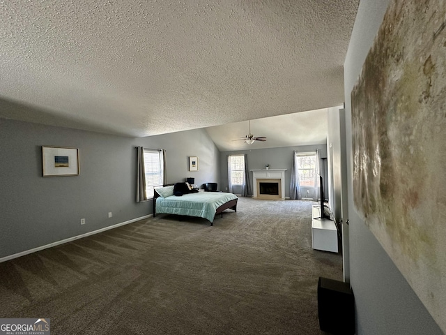 unfurnished bedroom with multiple windows, vaulted ceiling, carpet flooring, and a textured ceiling