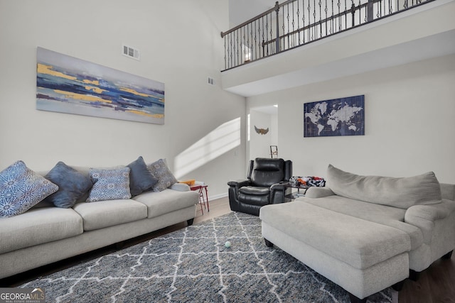 living room with hardwood / wood-style flooring and a high ceiling