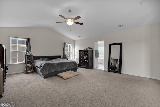 carpeted bedroom featuring vaulted ceiling, connected bathroom, and ceiling fan