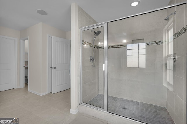 bathroom with a shower with door and tile patterned floors