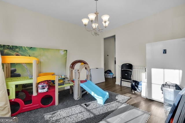 game room with a notable chandelier and dark hardwood / wood-style floors