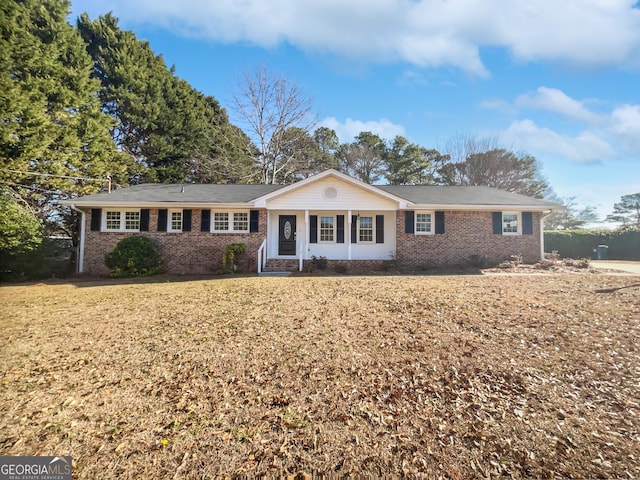 ranch-style house with a front yard and brick siding