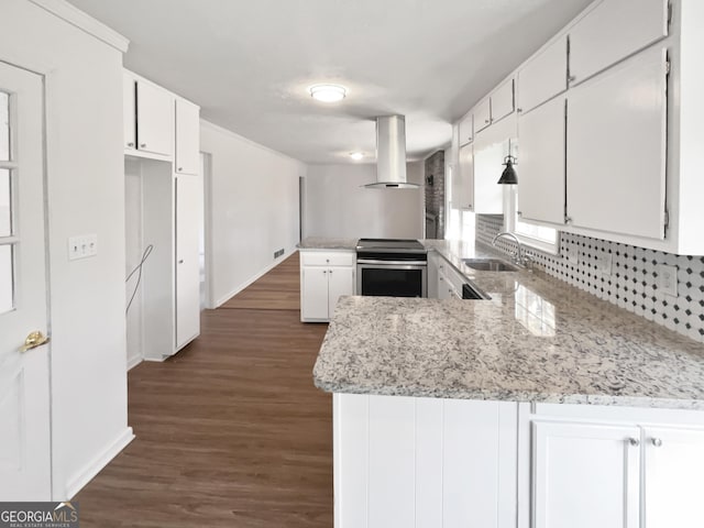 kitchen featuring stainless steel range with electric cooktop, white cabinets, island exhaust hood, sink, and kitchen peninsula