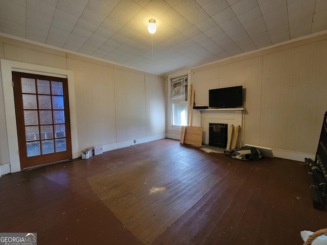 unfurnished living room with crown molding and dark hardwood / wood-style flooring