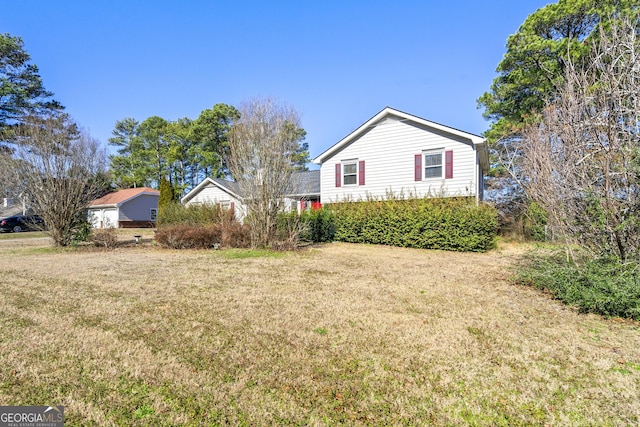 view of side of home with a lawn