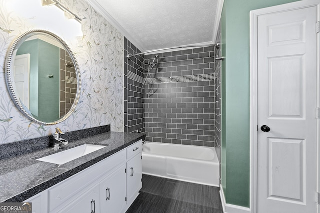 bathroom with tiled shower / bath combo, vanity, and a textured ceiling