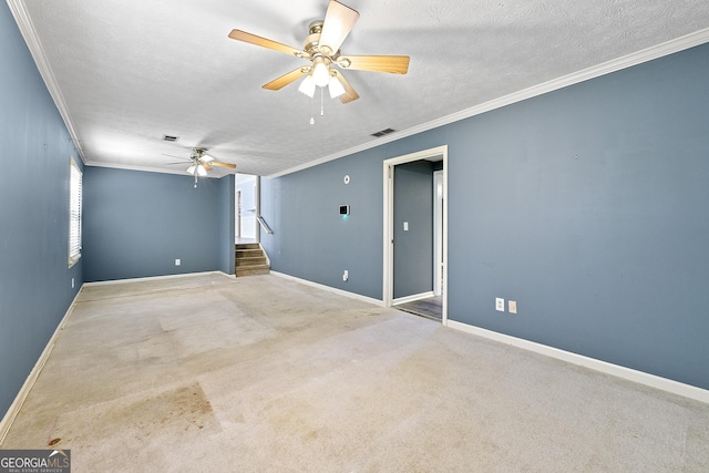 carpeted spare room with a textured ceiling, crown molding, and ceiling fan