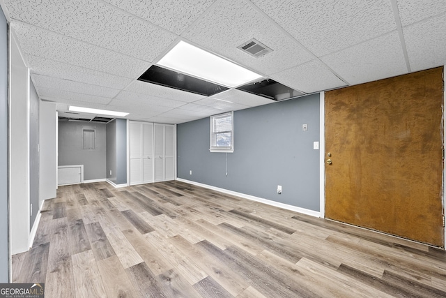 basement featuring light hardwood / wood-style floors and a drop ceiling