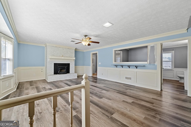 living room featuring plenty of natural light, wood-type flooring, and a textured ceiling