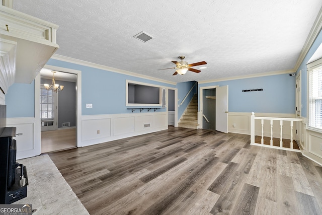 unfurnished living room featuring ceiling fan with notable chandelier, crown molding, wood-type flooring, and a textured ceiling