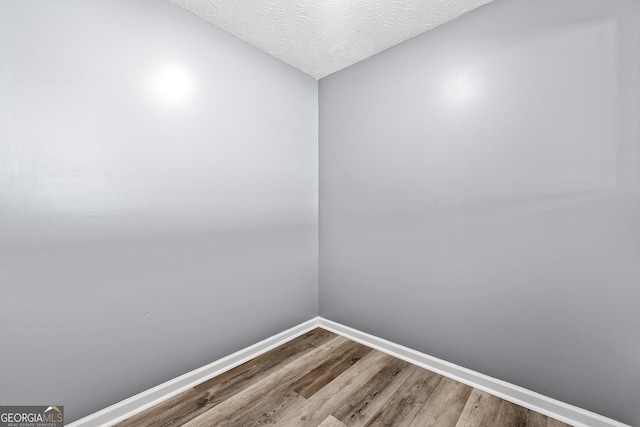 spare room featuring a textured ceiling and hardwood / wood-style floors