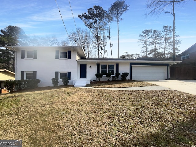 tri-level home featuring an attached garage, driveway, a front lawn, and stucco siding