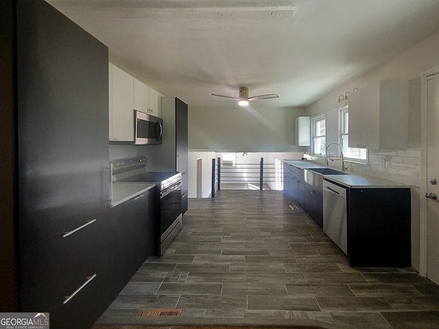 kitchen featuring white cabinetry, stainless steel appliances, sink, ceiling fan, and decorative backsplash