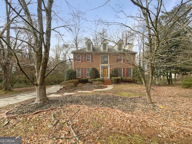 colonial house featuring brick siding