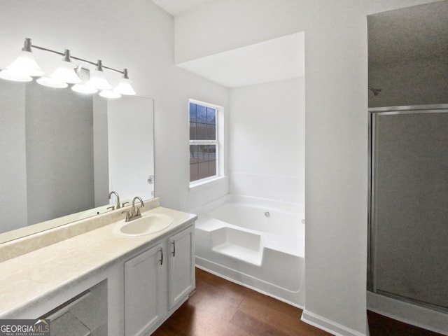 bathroom featuring a shower stall, a bath, and vanity