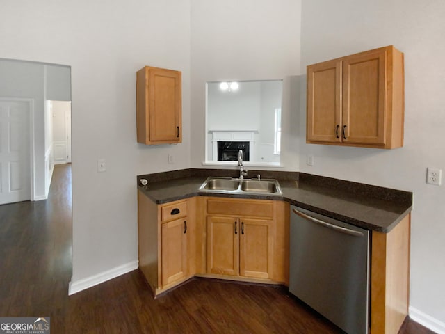 kitchen with dishwasher, dark wood-type flooring, dark countertops, and a sink