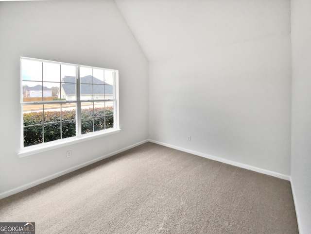 carpeted empty room with lofted ceiling and baseboards