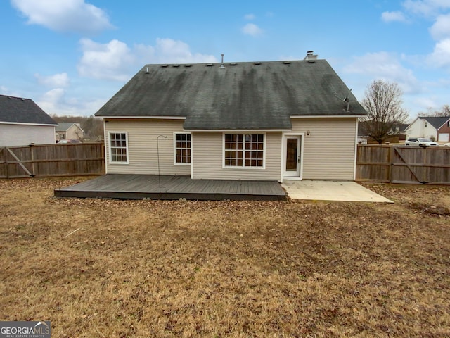 rear view of house featuring a patio area, a fenced backyard, a deck, and a yard